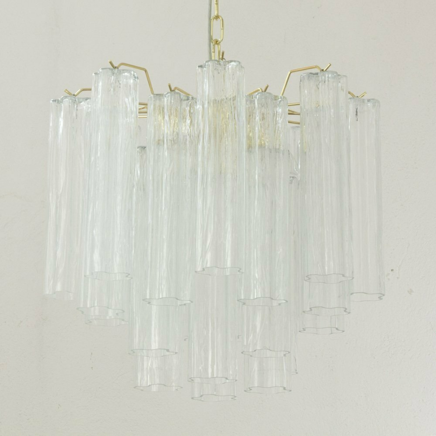 Clear glass chandelier with gold accents on a light gray background