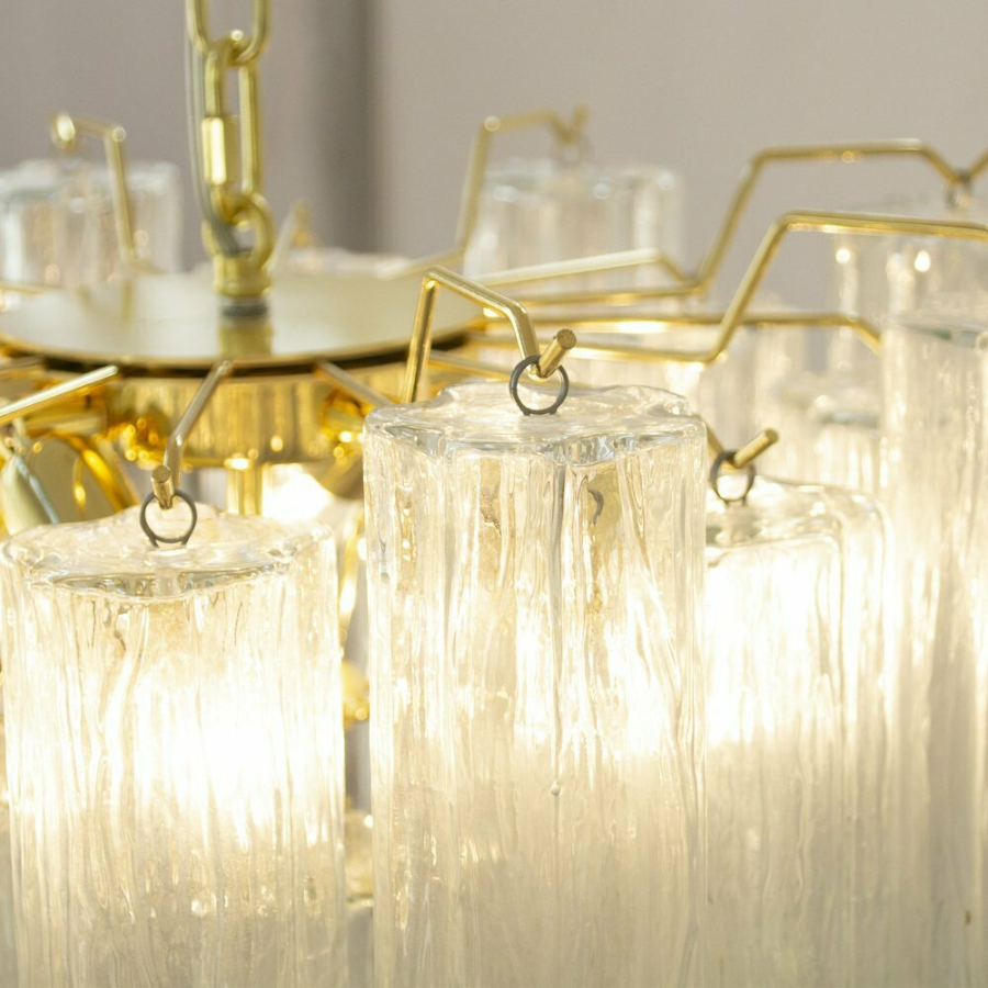 Close-up of a chandelier with gold frames and clear glass shades.