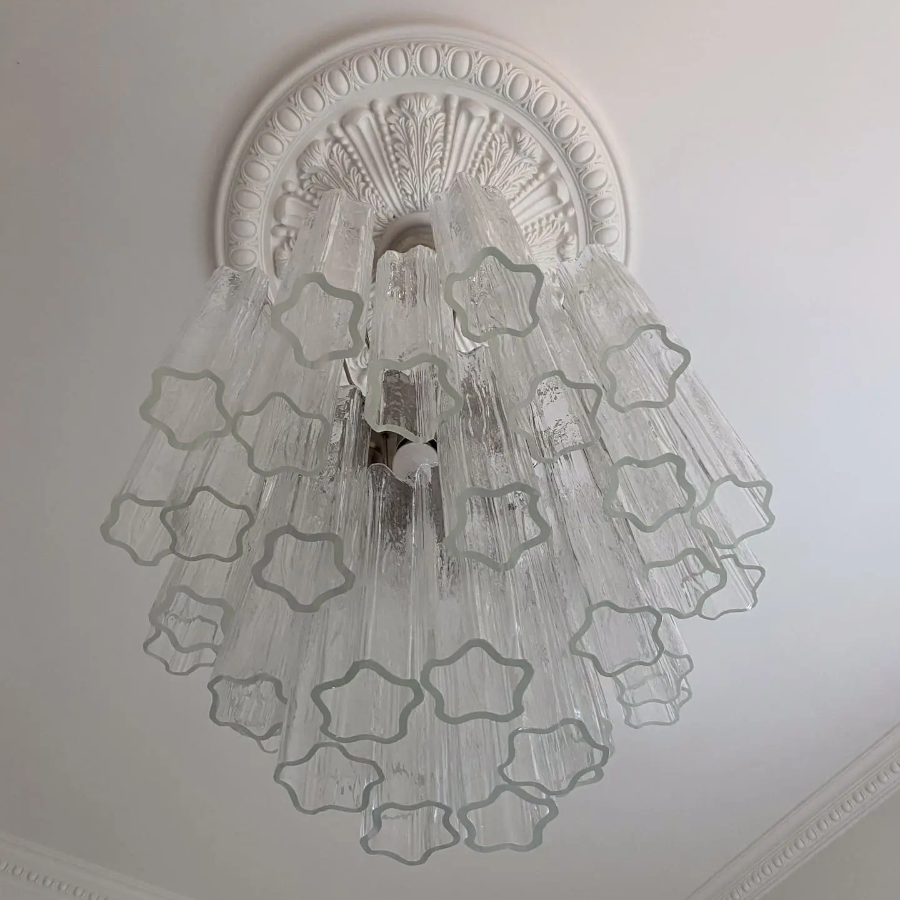 Decorative chandelier with star-shaped glass elements on a ceiling.